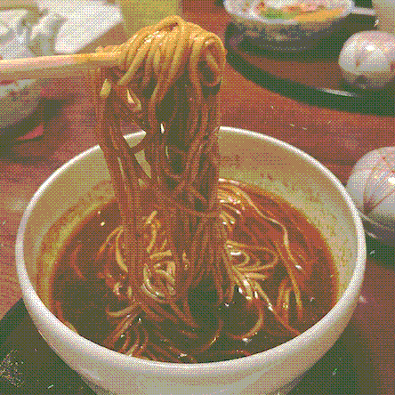 big steamy noodles being slowly pulled out of a bowl