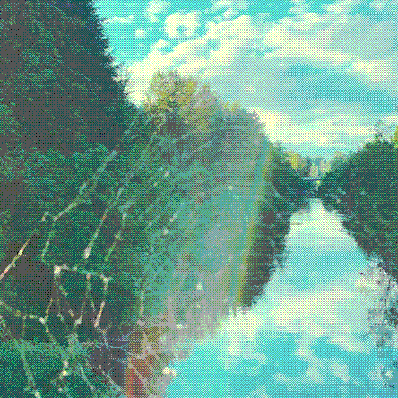 a picture of a river taken from a bridge, where the sky is reflected in the water below. the photo is taken through a spider web on the bridge and there is a colorful lens flare from the sunlight. the area around the river is very lush.